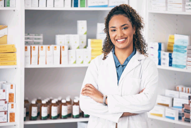 Pharmacist in a white coat standing confidently in front of pharmacy shelves